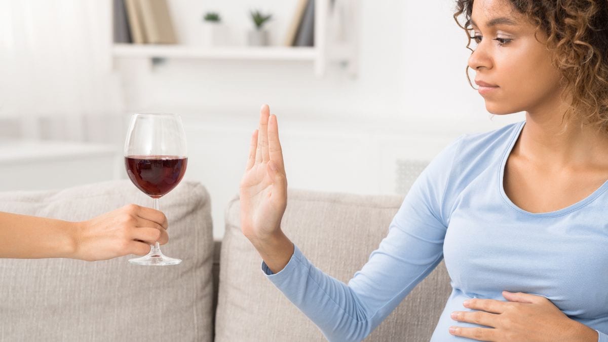 Pregnant woman refusing a glass of wine