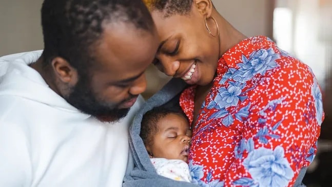 parents holding sleeping infant