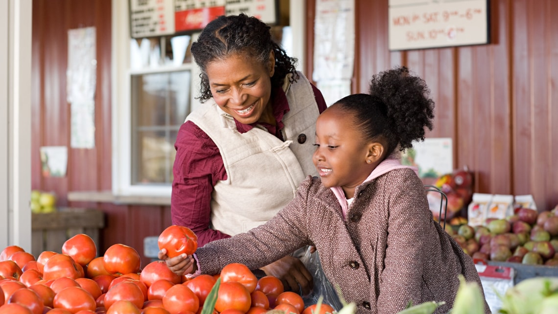 Mother and daughter choosing vegetables at a farmer's market