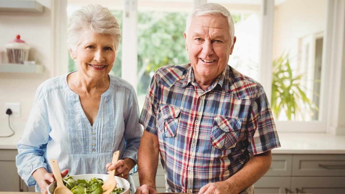 a man and a woman making a salad