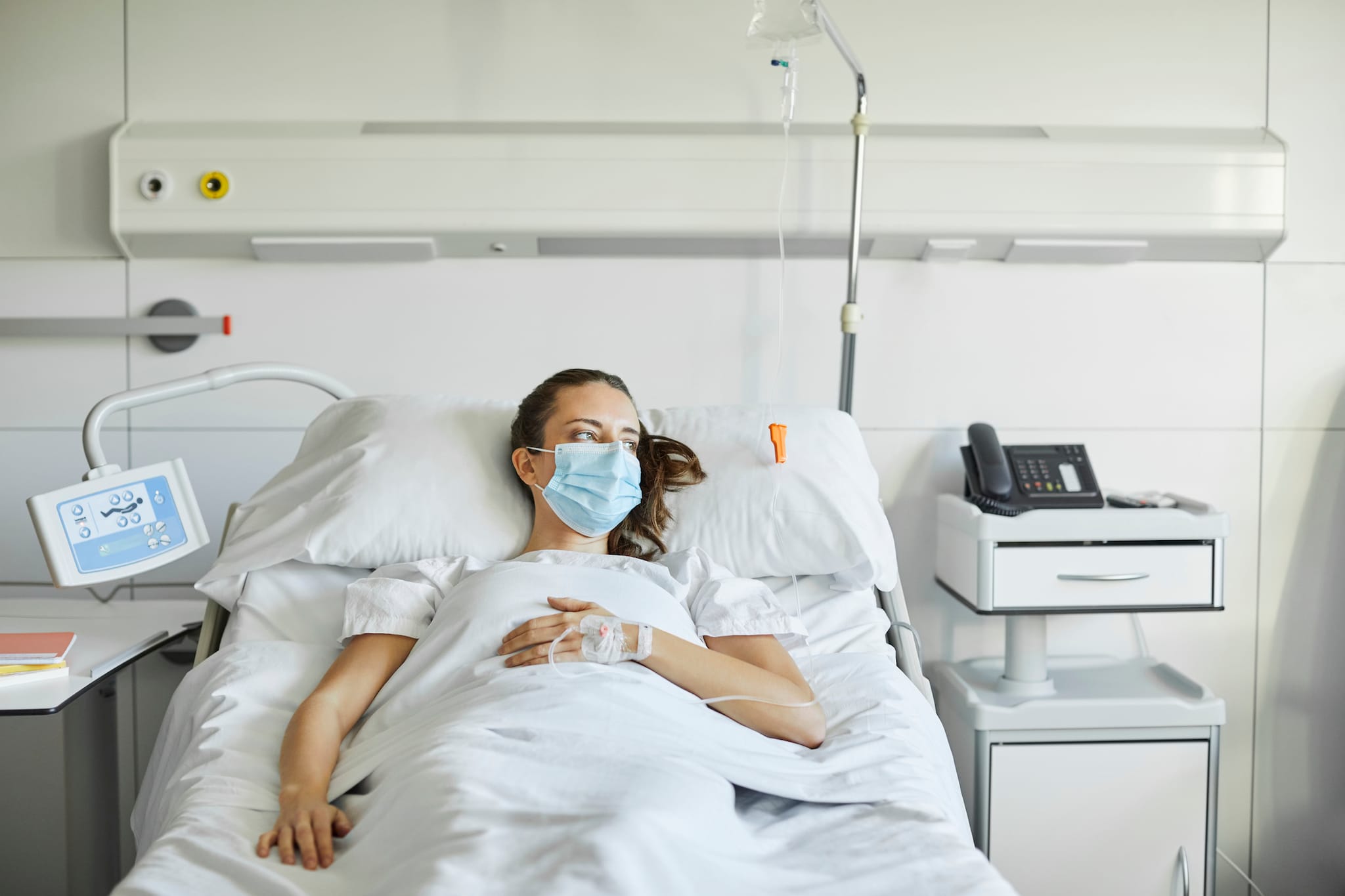 Woman lying in hospital bed.