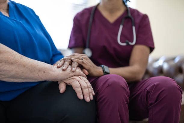 Health care professional comforting long-term care resident.