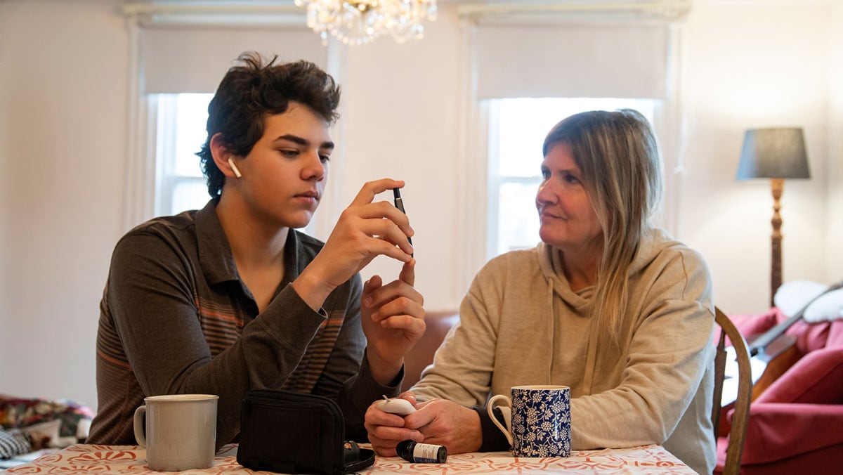 A diabetic teen patient at home with his mother.