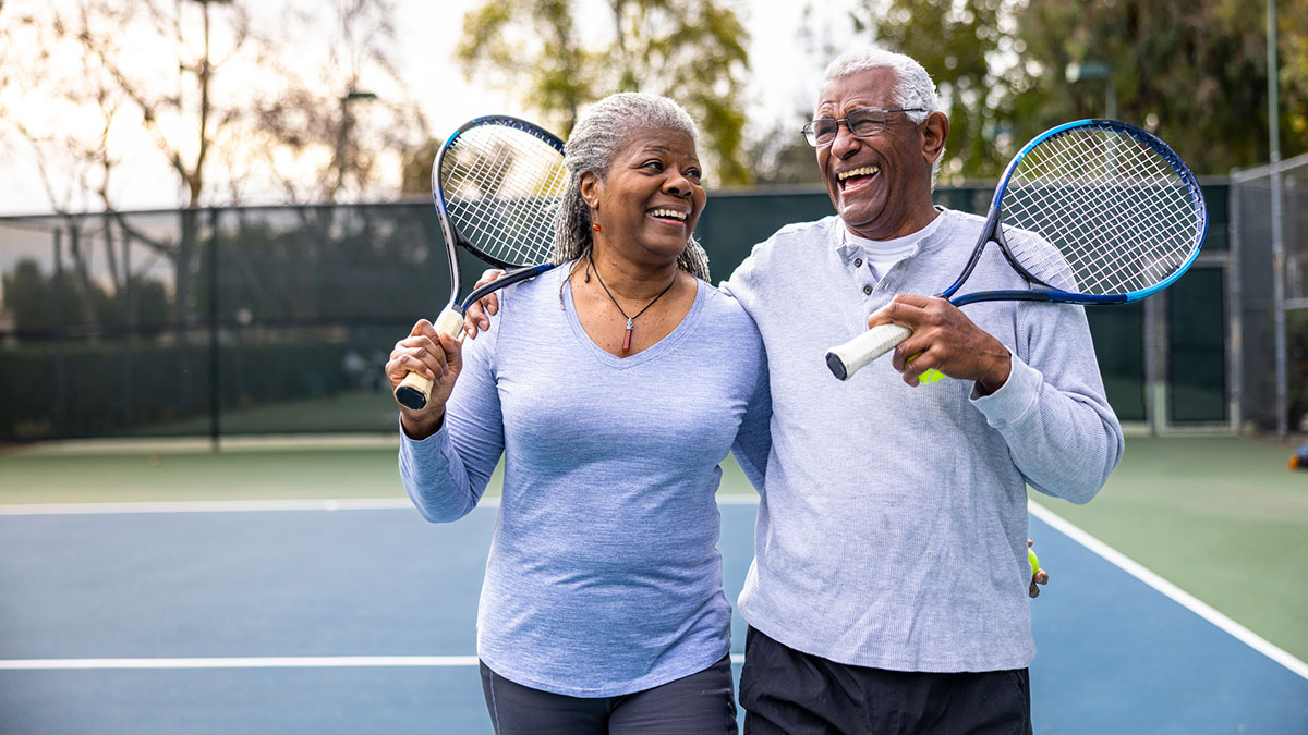 couple carrying tennis rackets