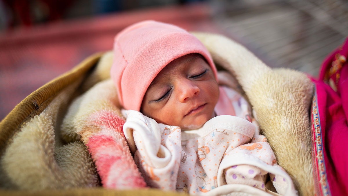 A sleeping baby wrapped in a blanket.