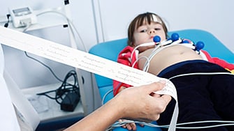 A doctor looks over results from a child’s electrocardiogram