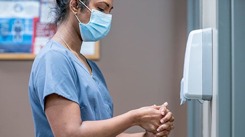 A healthcare provider using hand sanitizer.