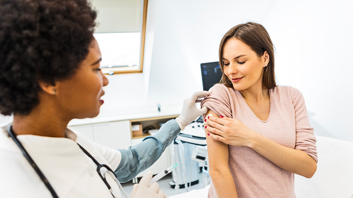 A healthcare professional administering a vaccine to a pregnant woman