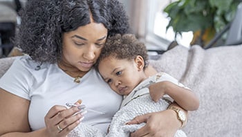 A mother snuggles with her sick child.