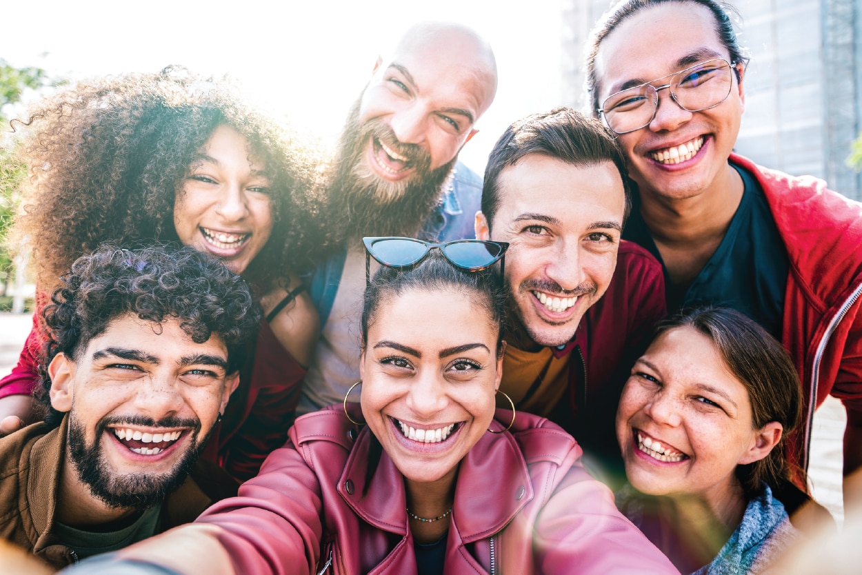 A group of people huddled together, smiling.