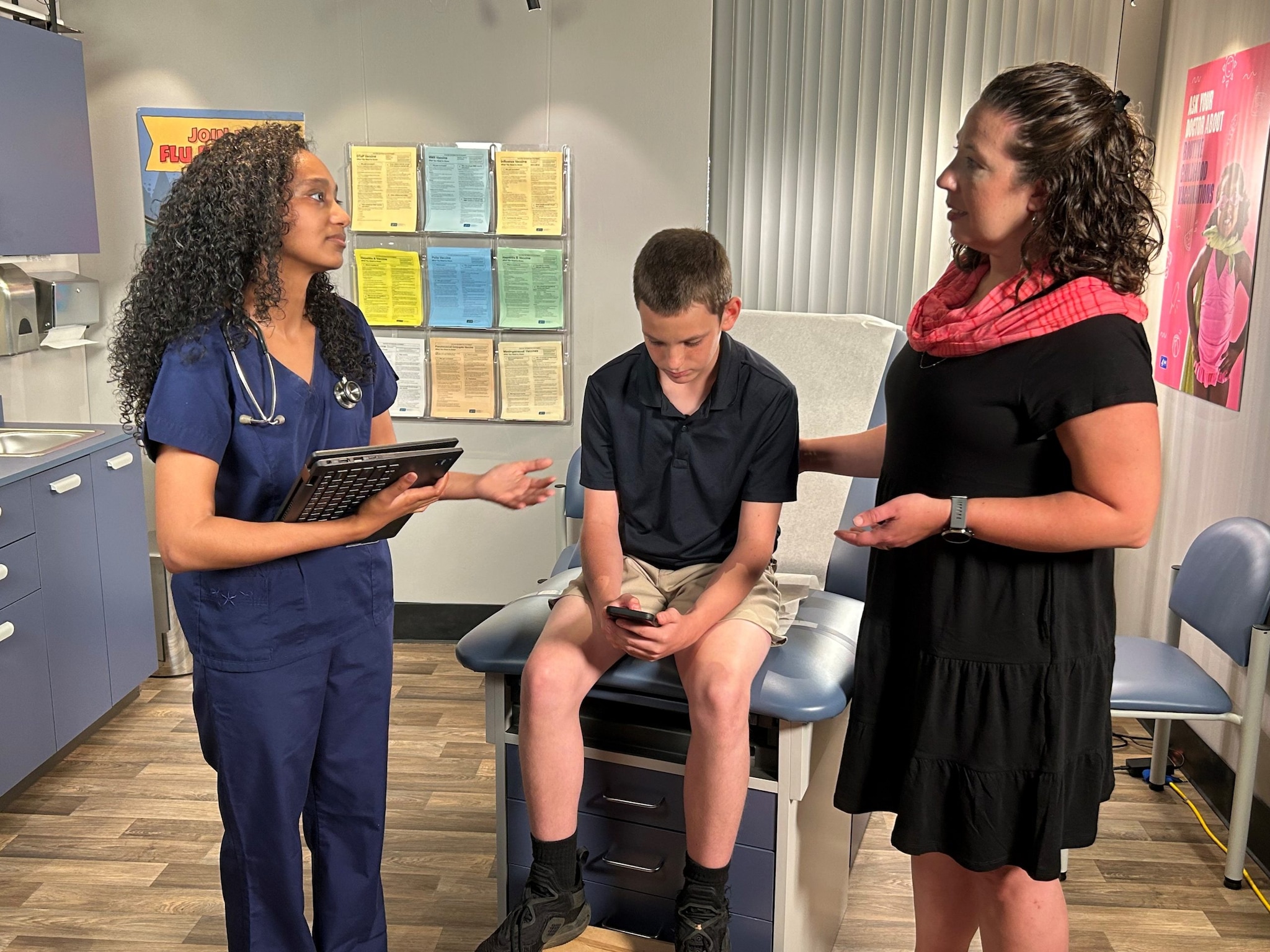 Doctor speaking with parent and child about HPV vaccine.