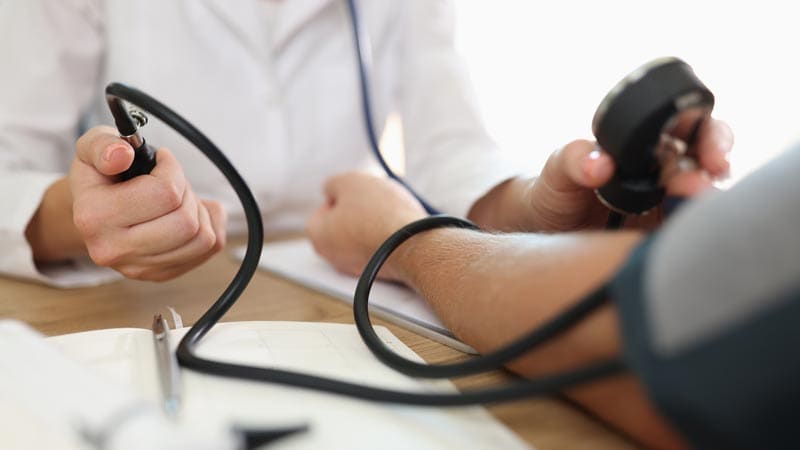 Doctor taking patient's blood pressure