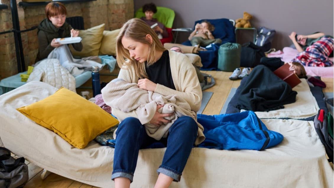 Mother caring for her baby in a shelter setting.