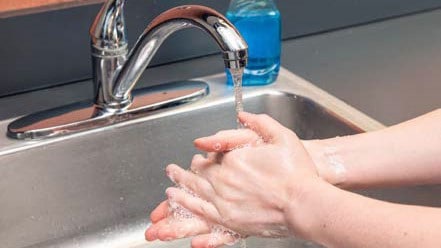 Person washing their hands.