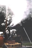 Fogging machine spraying insecticide in an open area