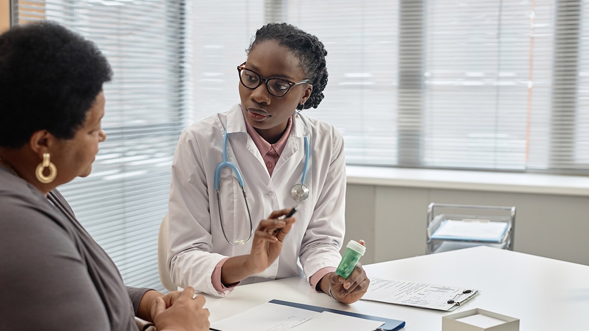 Clinician speaking to a patient about medications that prevent malaria.