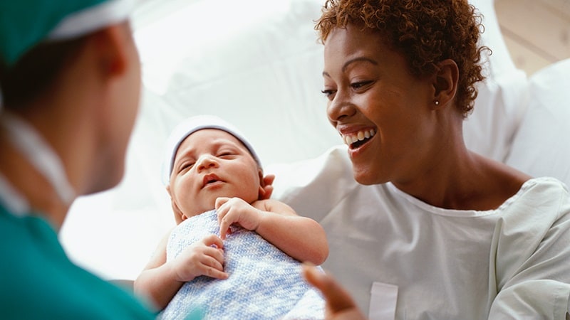 doctor putting infant in mother's arms