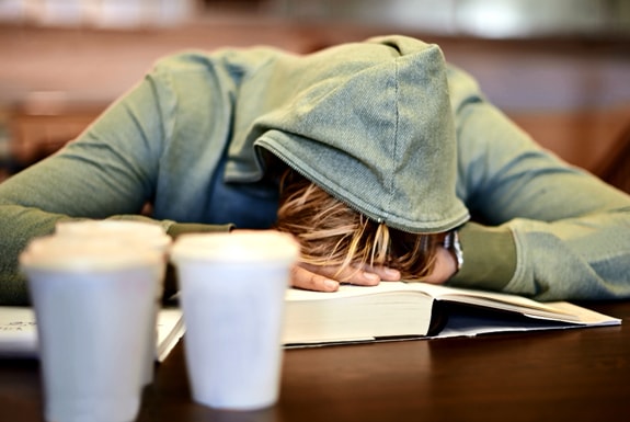 teen sleeping on his school desk