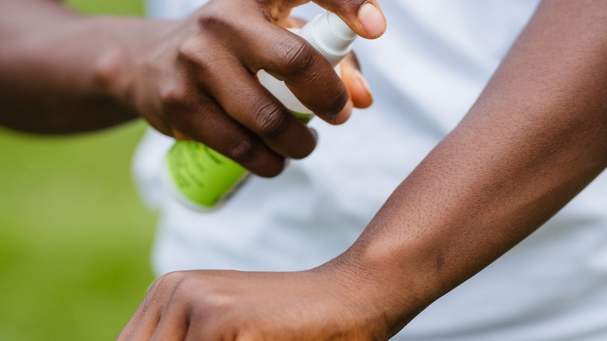 Person applying insect repellent to their arm