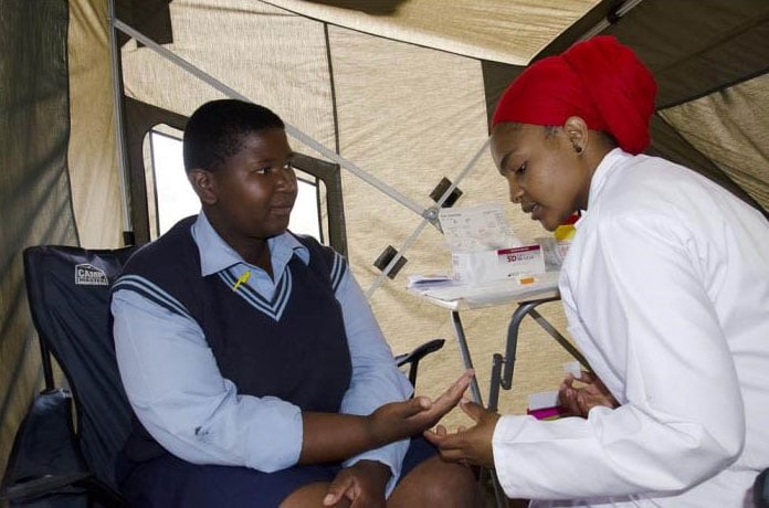 Two adults interacting in a medical tent