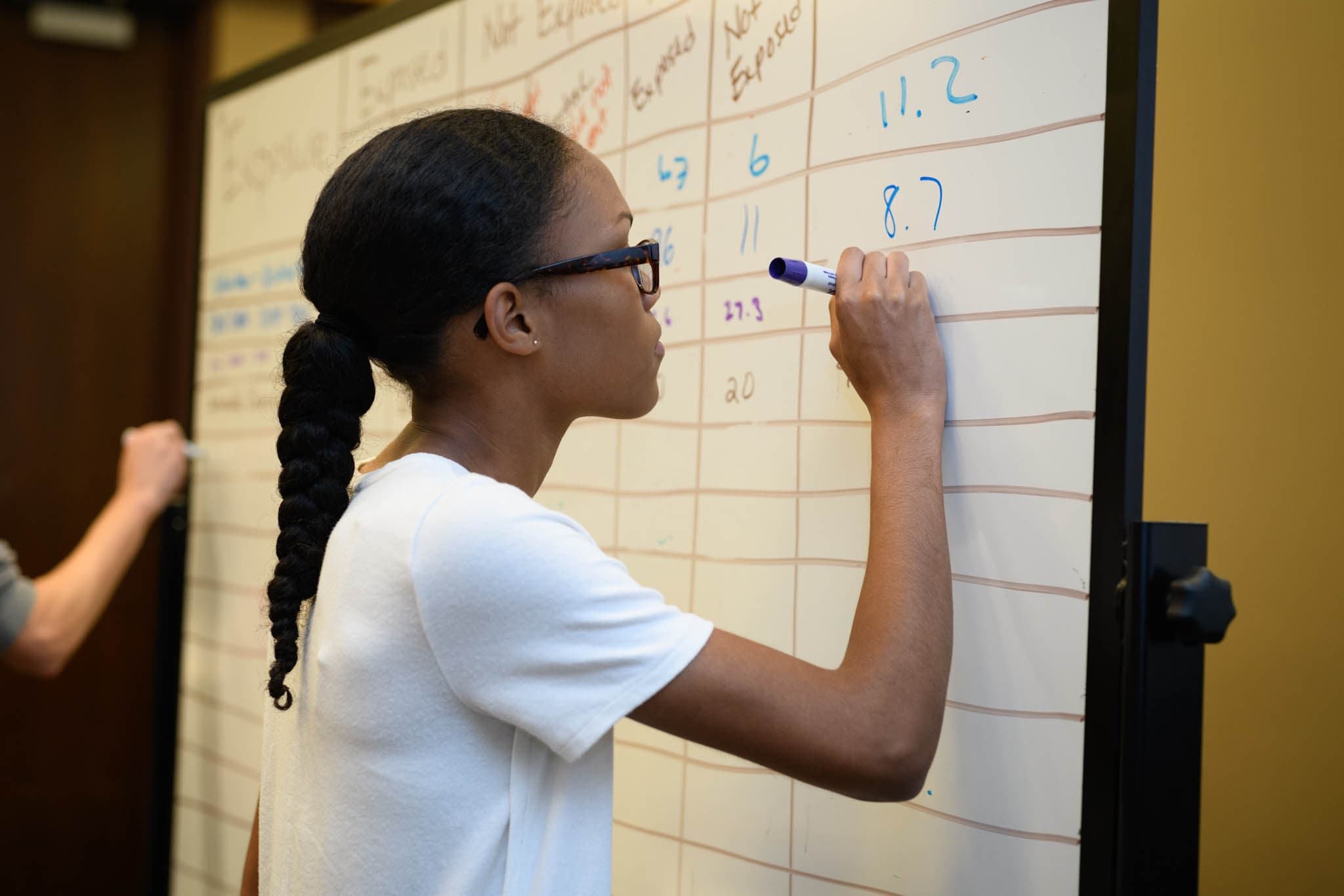 Student writing on a whiteboard.