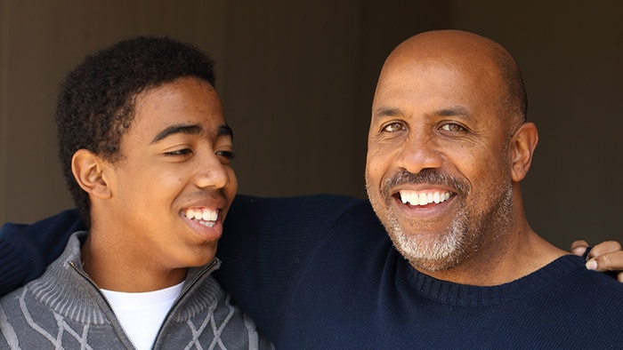 Parent and teen smiling and embracing