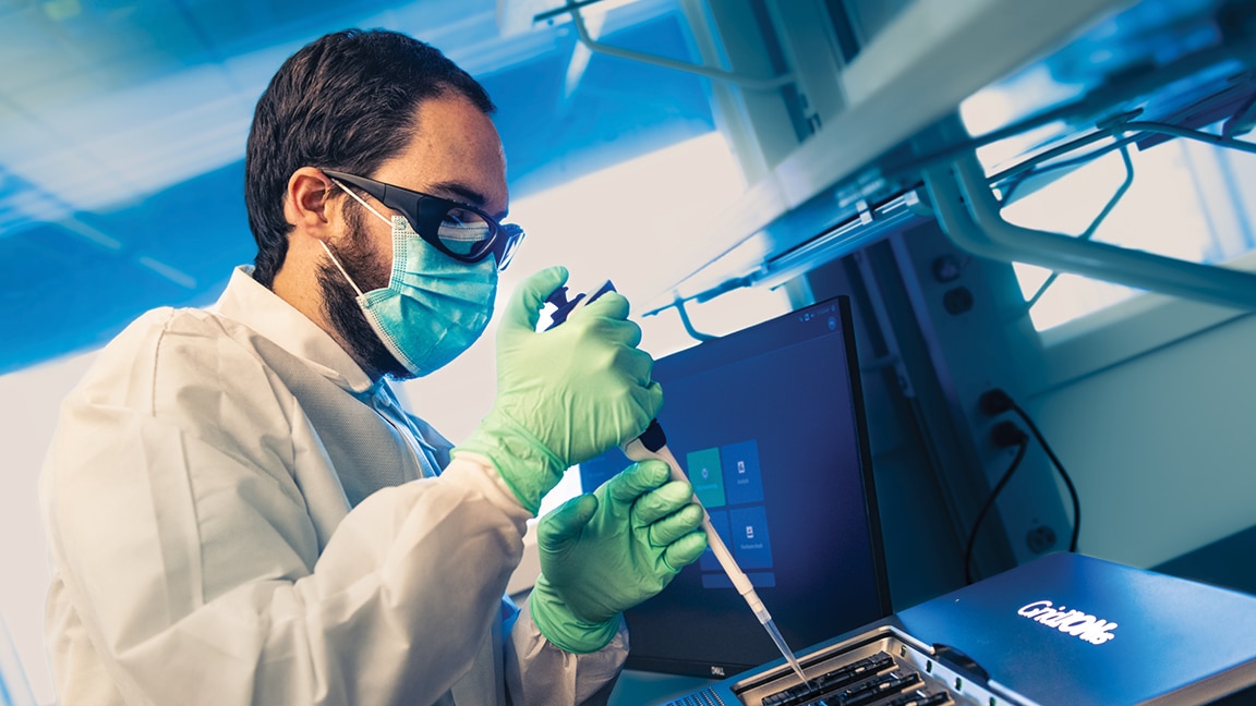 Photo of a male laboratory worker using a pipette