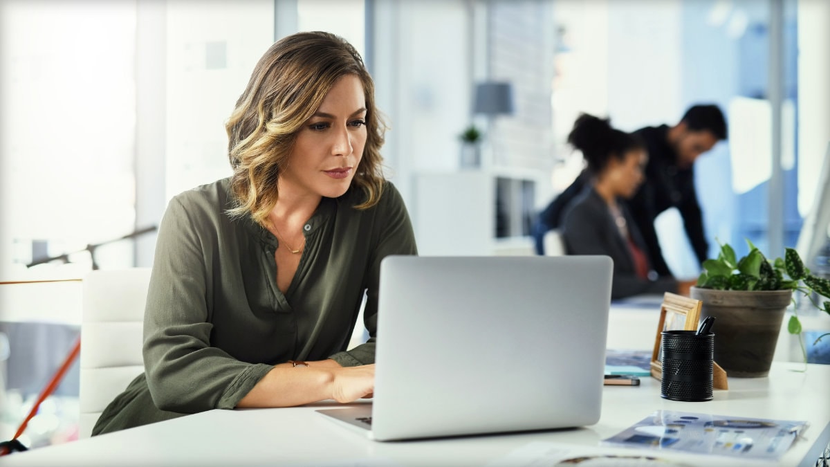 A woman working at her laptop in an indoor setting