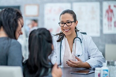 A parent and child meet with a health care provider.