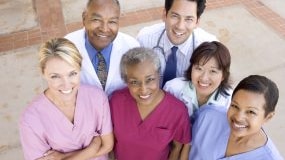 Group of healthcare workers smiling for picture.