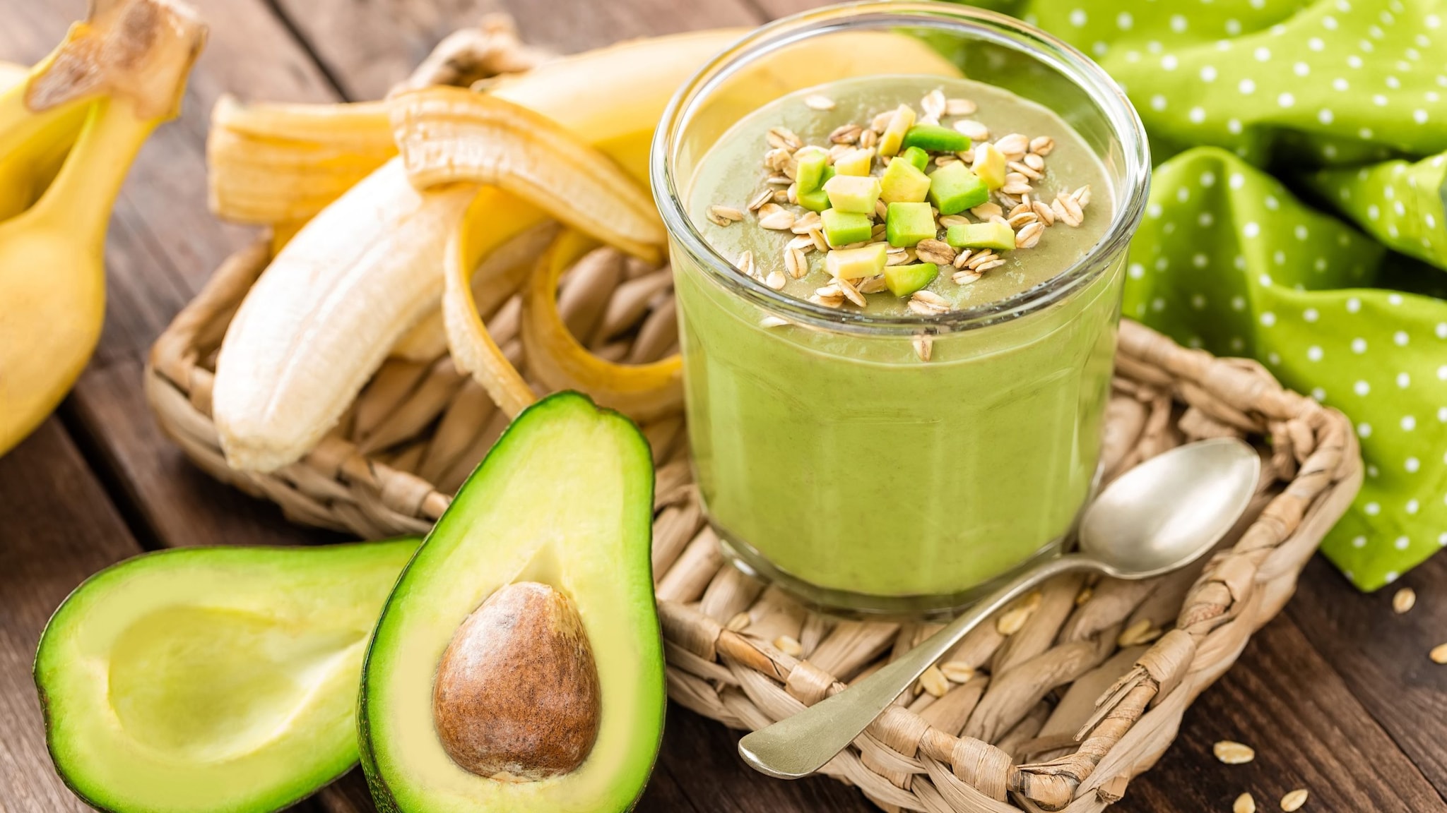 A photo of a smoothie bowl accompanied with sliced avocado and banana.