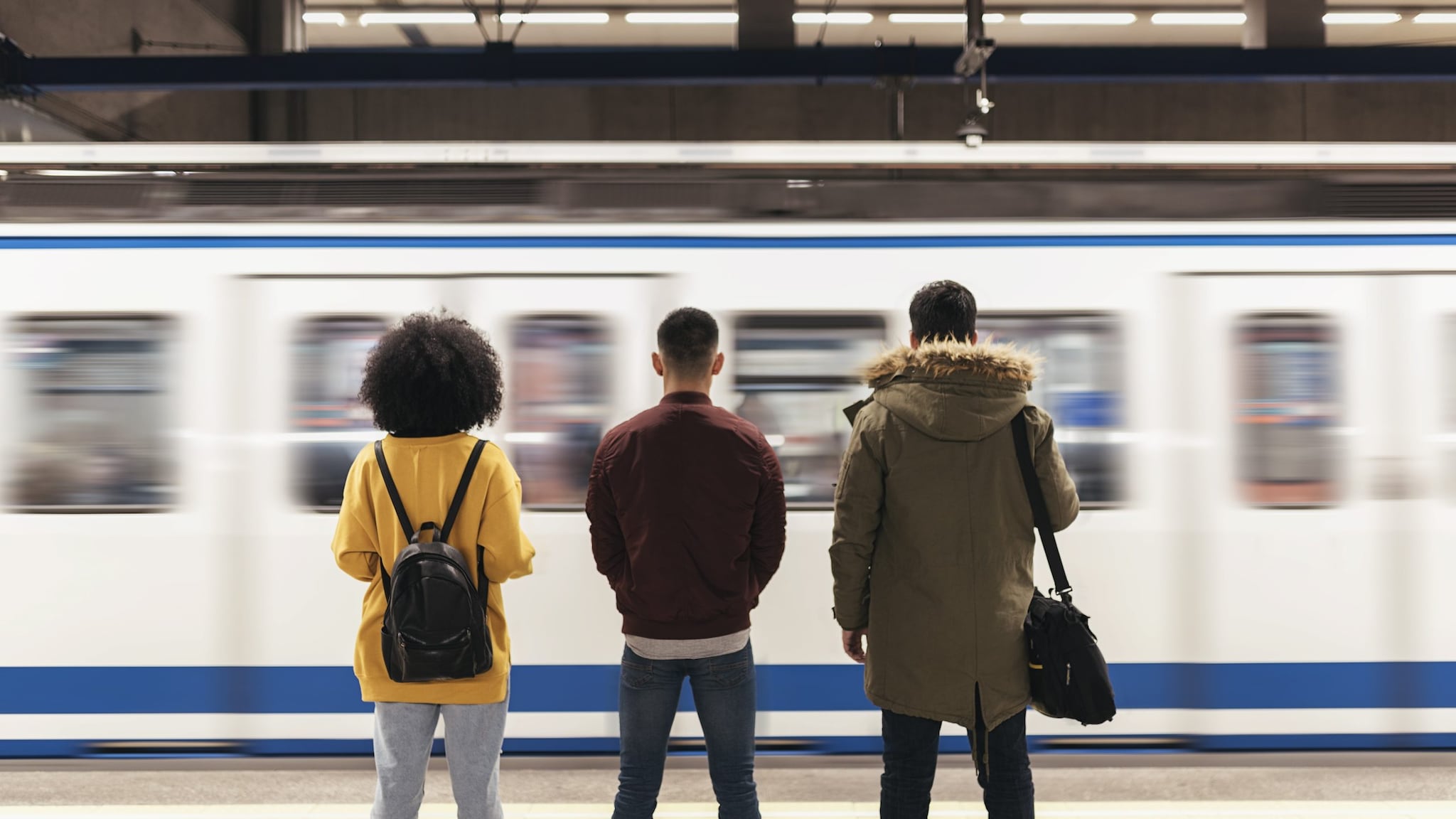 Three friends at a train platform.