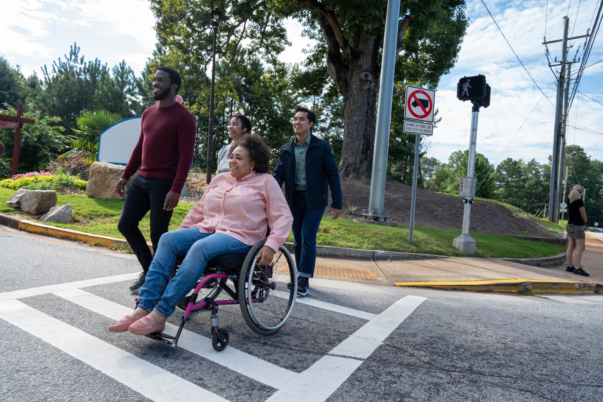 A group of adults walking across the street, using a crosswalk.