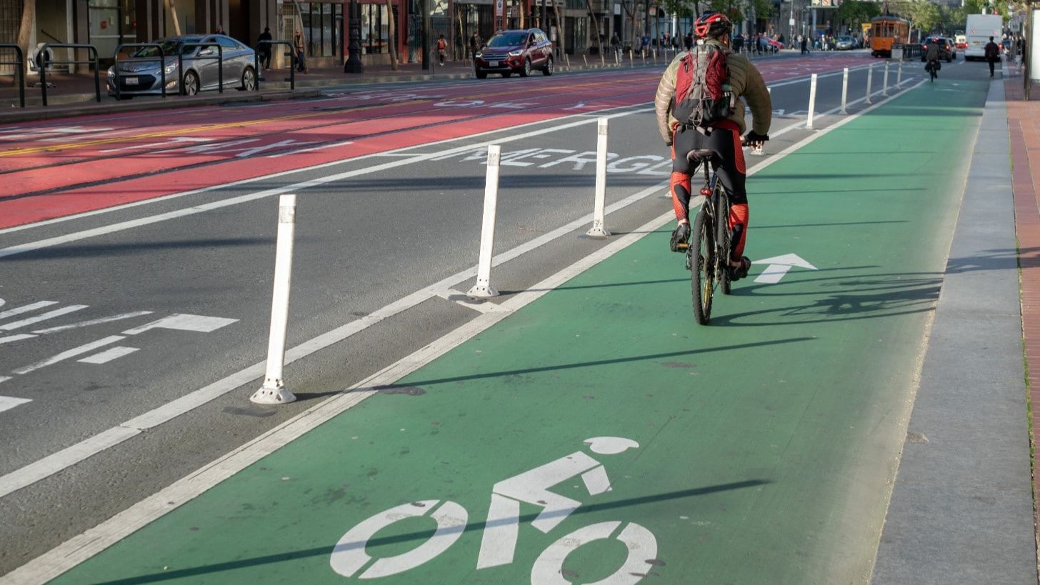 Person riding a bike in a bike lane next to a street.