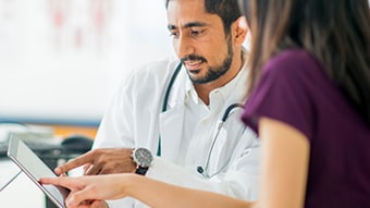 Two healthcare providers looking at something on a tablet