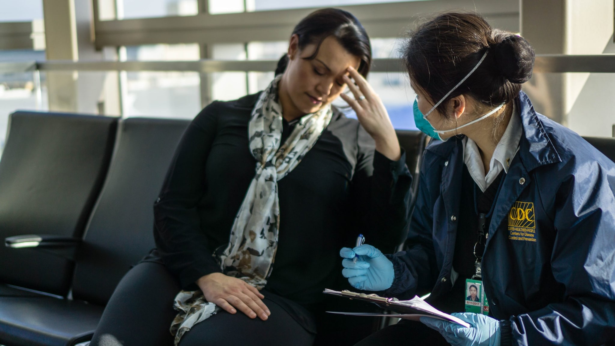 Port health station staff member interviews a sick traveler