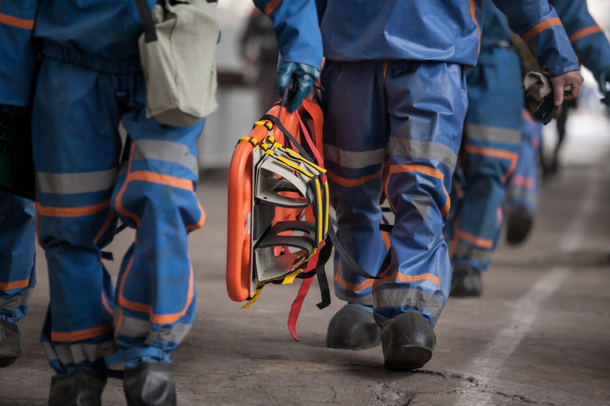 Medical evacuation worker walking while holding a stretcher at their side during a mass casualty training