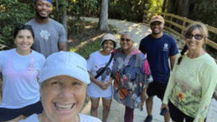 A group of people taking a selfie photo outside.