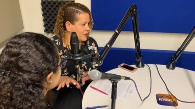 Two people at a table with radio microphones in front of them.