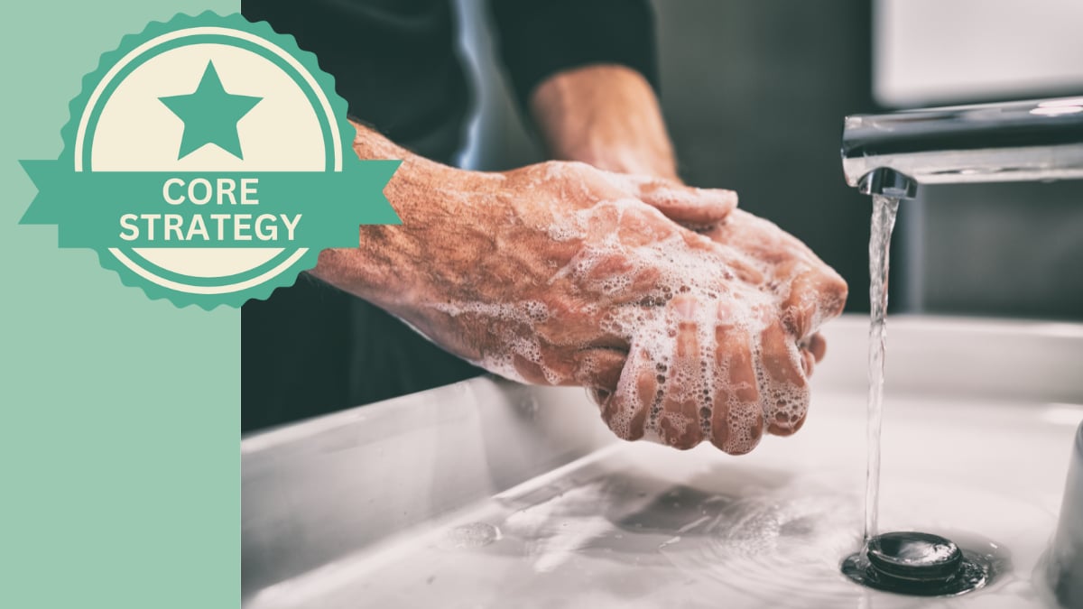 Man soaping up his hands over a bathroom sink.