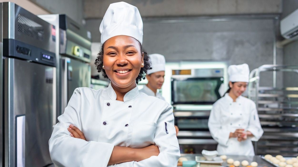 Kitchen manager with staff members working in the background.