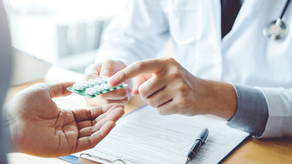 A doctor giving prescription medication to patient