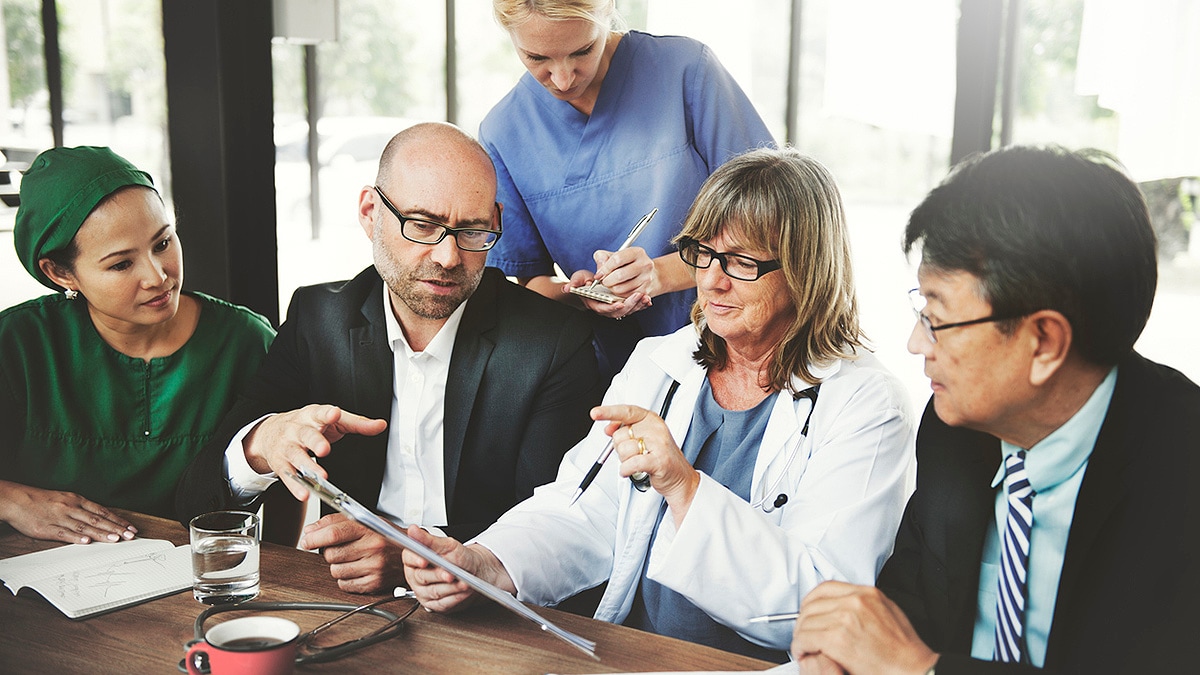 Medical and other community representatives collaborating at a conference table.