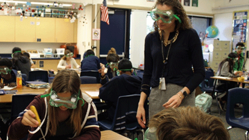 A teacher with young students in a classroom.