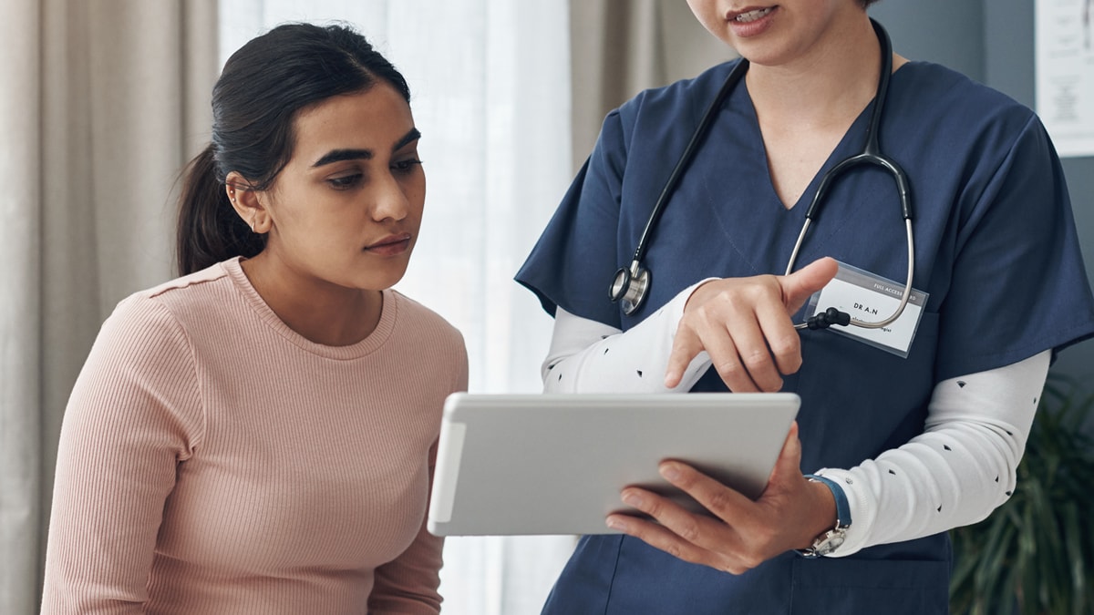 a young woman looking at a screen with her healthcare provider