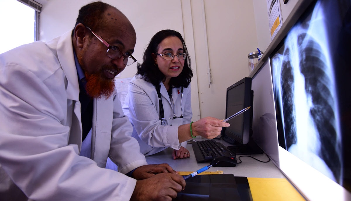 Two health care providers review a patient's chest x-ray.