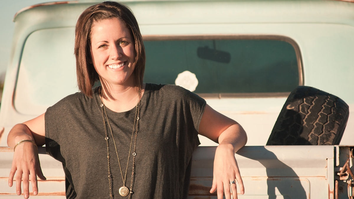 Woman leaning on truck tailgate