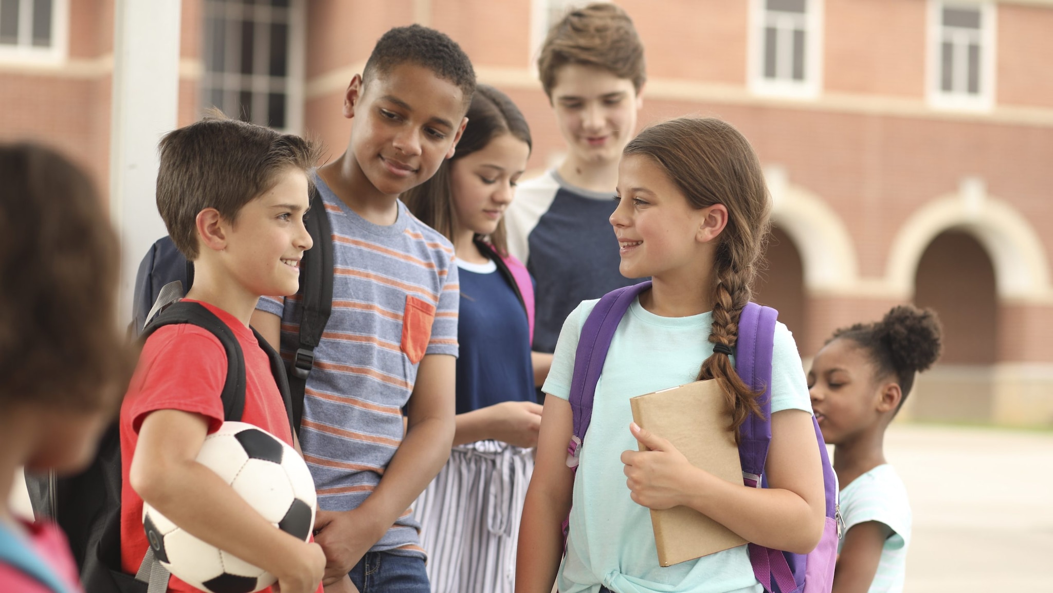 Middle school students socialize outside.