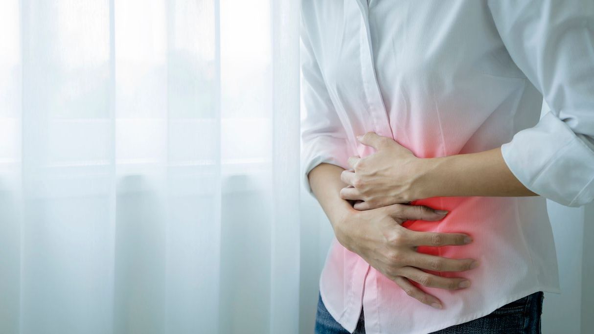 Woman clutching her stomach.